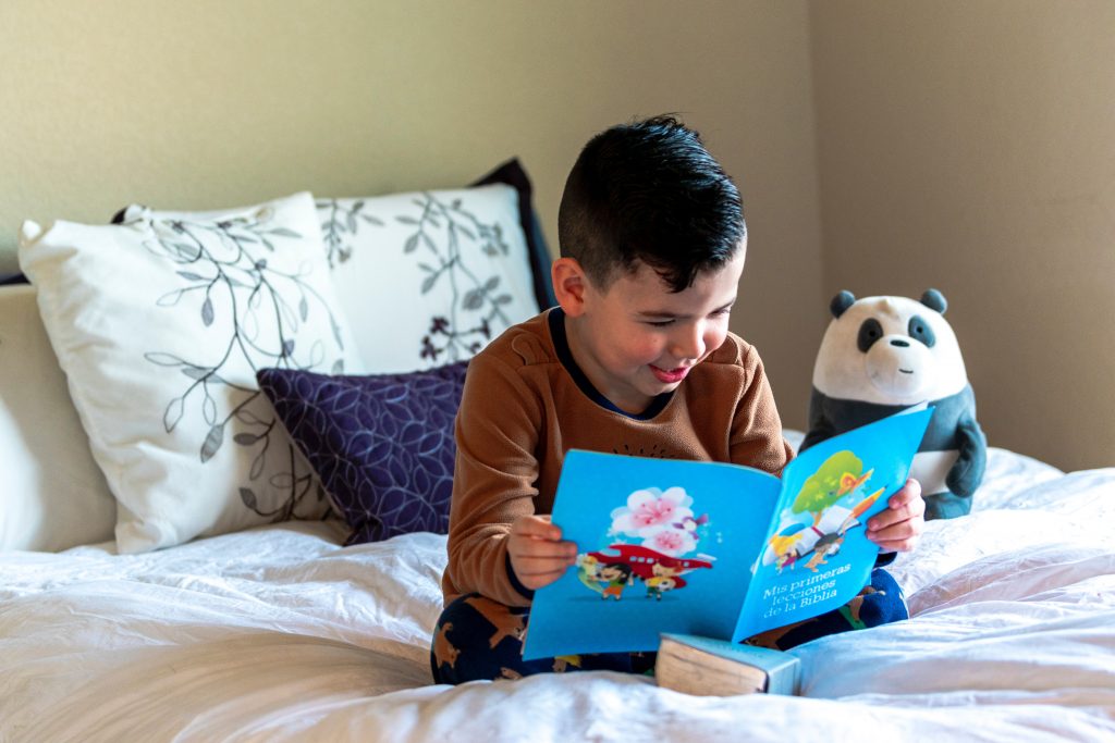 Kurze Vorlesegeschichten für Kinder Junge auf dem Bett mit Buch