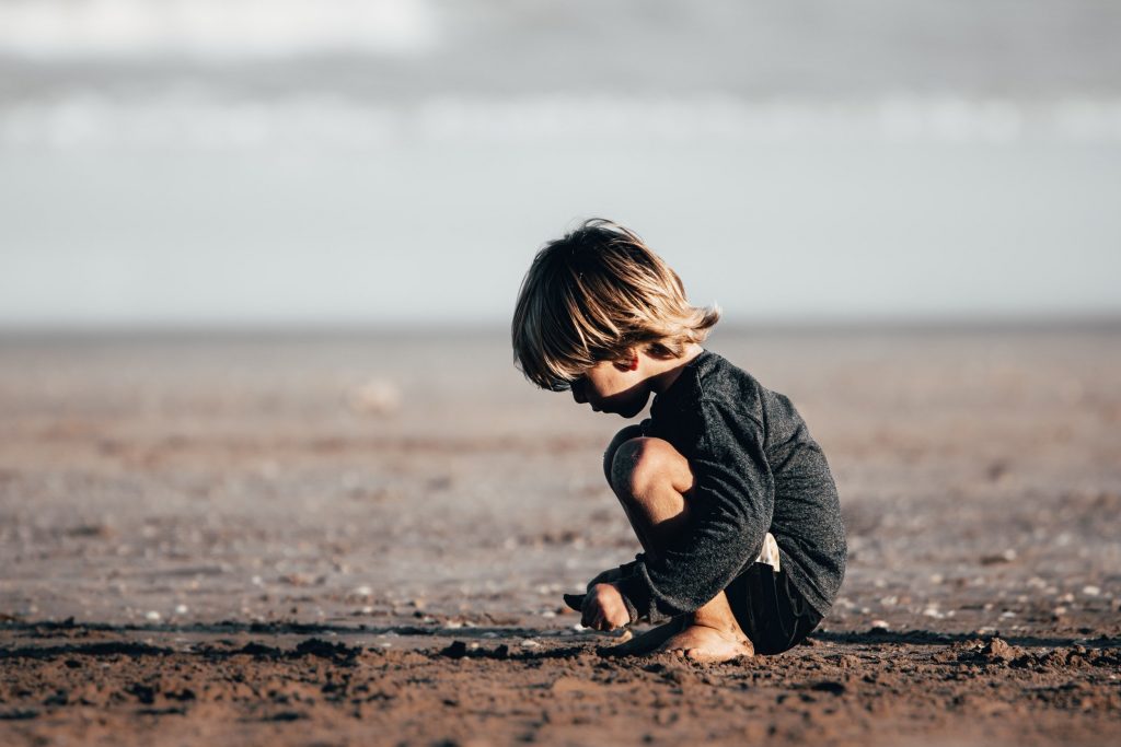 Traumreisen für Jungs Kind spielt im Sand
