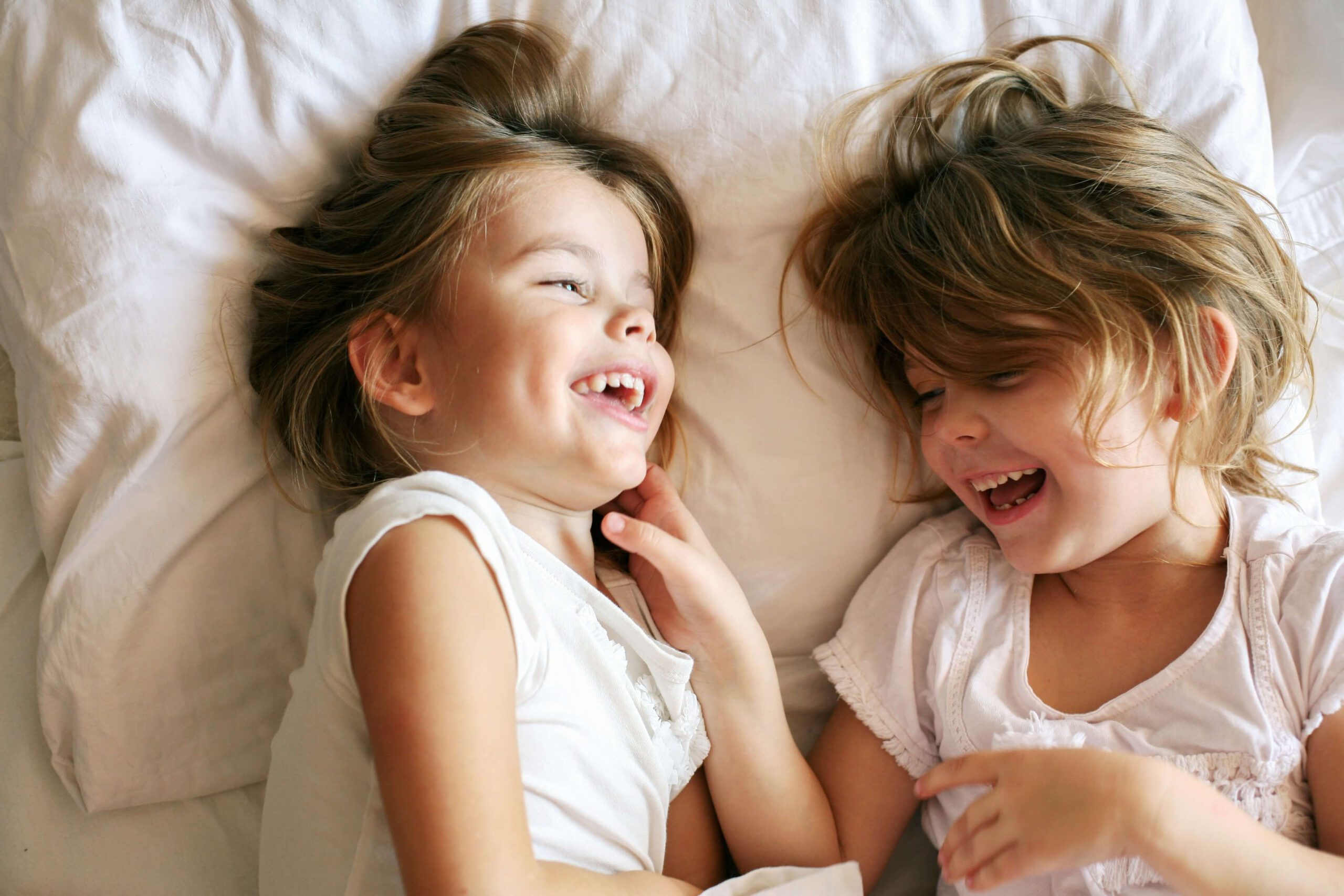 Kurze Gute Nacht Geschichten für Kinder Zwei Mädchen albern im Bett herum