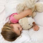 Geschichten zum Vorlesen Mädchen schläft mit Teddy im Bett