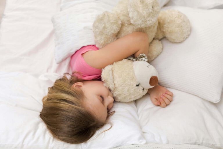 Geschichten zum Vorlesen Mädchen schläft mit Teddy im Bett